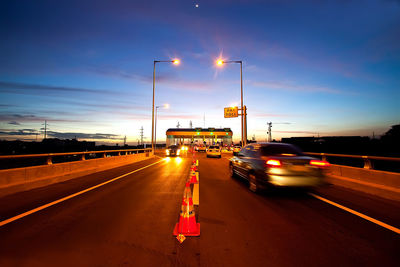 Light trails on road against sky at night