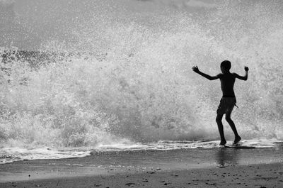 Full length of man standing on shore at beach