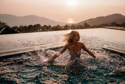 Girl in the pool at sunset