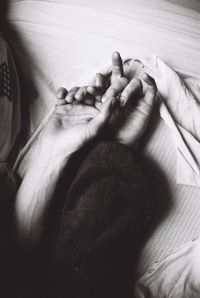 High angle view of woman hand on bed