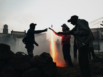 Silhouette men standing against clear sky