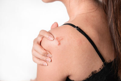 Close-up of woman with hand on white background