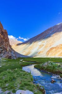 Scenic view of lake and mountains against blue sky