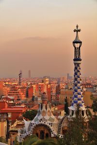 High angle view of art nouveau church tower against cityscape at sunset