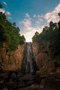 Scenic view of waterfall against sky