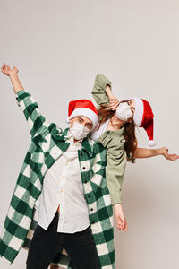 Portrait of couple gesturing against gray background