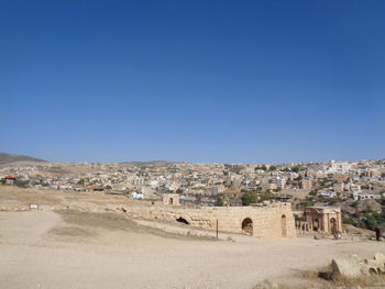 Buildings in city against clear blue sky