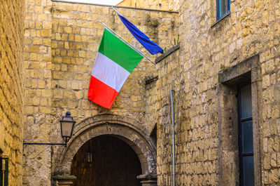 National italian flag on the facade of old house building