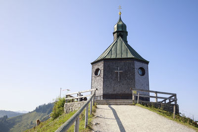 Tower amidst buildings against clear blue sky