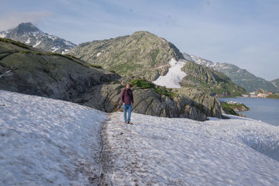 Portrait of man standing on snow covered rock