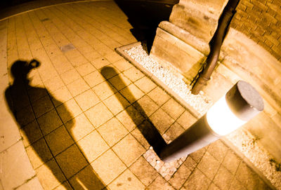 High angle view of shadow of people on tiled floor