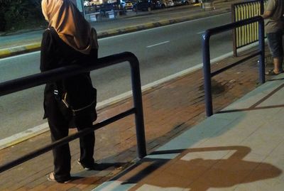 Low section of woman standing on street in city