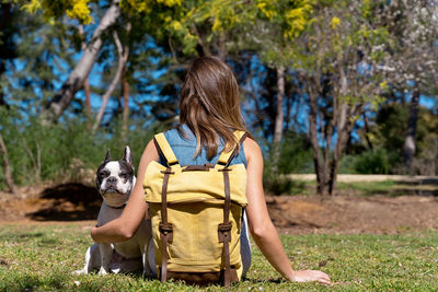 Rear view of woman with dog on field