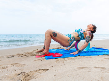 Side view of senior woman on beach against sky