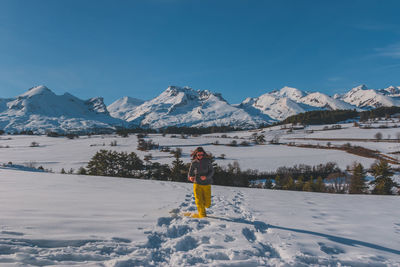 A full-body shot of a young caucasian woman running towards the camera in the french alps mountains