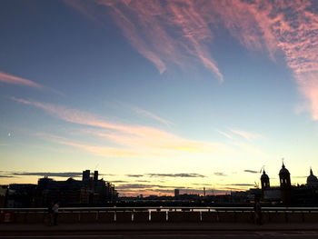 Silhouette city against sky during sunset