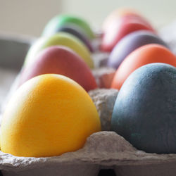 Close-up of multi colored eggs in carton