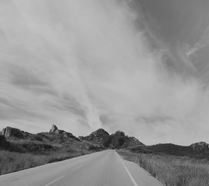 Empty road along landscape against sky