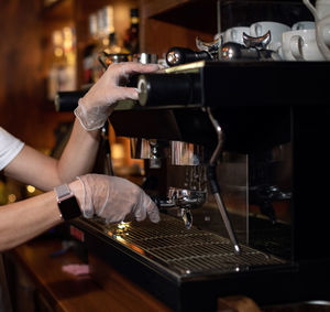 Girl makes espresso in a coffee machine. barista is making coffee. 