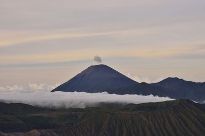 Scenic view of mountains against cloudy sky during sunset