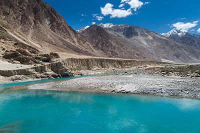 Scenic view of lake and mountains against blue sky