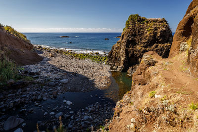 Scenic view of rocks on beach against sky