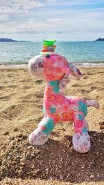 Close-up of toy on beach against sky
