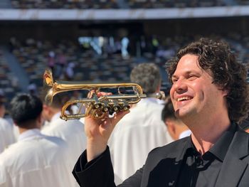 Portrait of smiling man holding camera at music concert