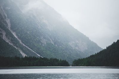 Scenic view of lake by mountains against sky