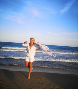 Full length of man standing at beach against sky