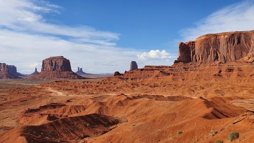 View of rock formations against cloudy sky, monument valley