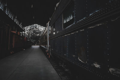 Illuminated railroad tracks amidst buildings in city at night