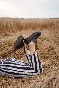 Low section of woman on field against sky