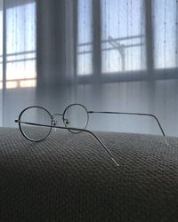 Close-up of eyeglasses on table against window