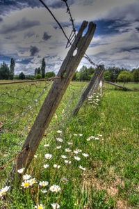 View of wooden fence on field against sky