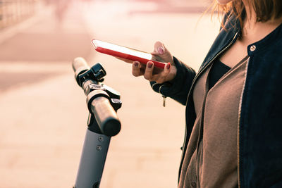 Midsection of woman using mobile phone