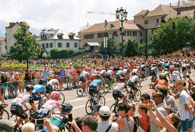 People on street against buildings in city