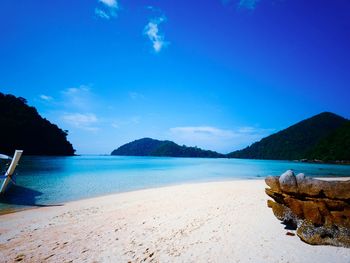 Scenic view of beach against blue sky