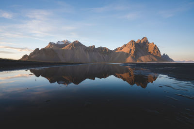 Scenic view of lake and mountains against sky during sunset