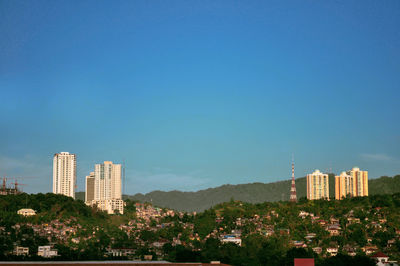 Cityscape against clear blue sky