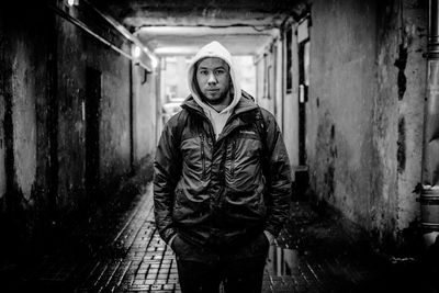 Portrait of young man standing against wall