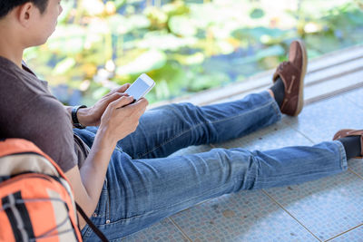 Midsection of man using mobile phone