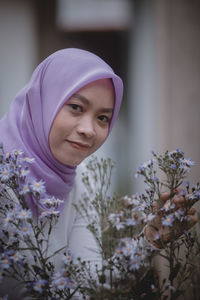 Portrait of smiling woman with purple flower