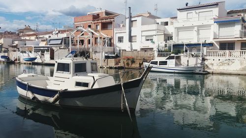 Boats moored on shore against sky