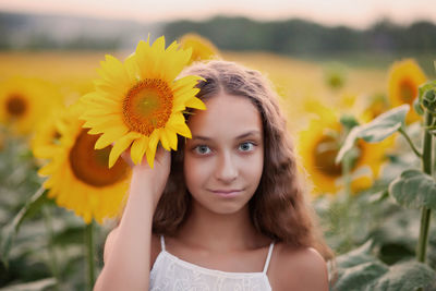 Portrait of girl with yellow flower