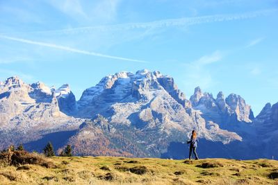 Woman walking on mountain against sky