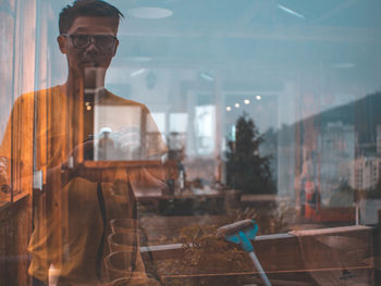 Reflection of man photographing on store window