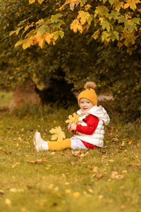 Full length of girl sitting on field