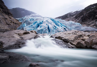 Scenic view of waterfall against sky