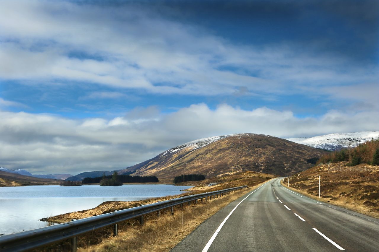 cloud - sky, road, sky, transportation, mountain, direction, the way forward, beauty in nature, scenics - nature, sign, tranquil scene, road marking, tranquility, marking, nature, symbol, non-urban scene, no people, diminishing perspective, day, mountain range, outdoors, dividing line, long